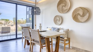 Un espace repas comprenant une table, des chaises et un luminaire suspendu.