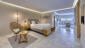 Une chambre à coucher moderne avec un lit, une table de chevet, une chaise et une vue sur la salle à manger.