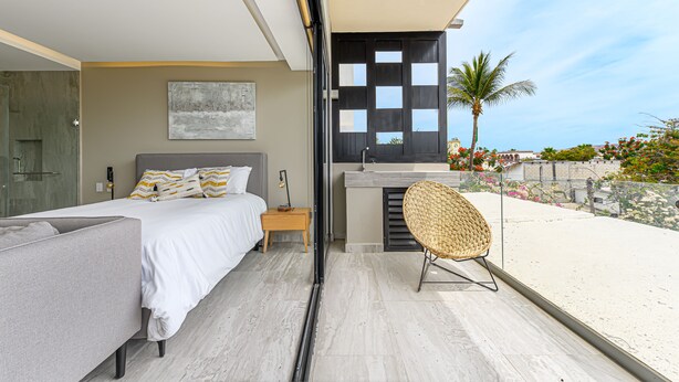 Une chambre moderne avec un lit, une table de chevet et une vue sur la plage.