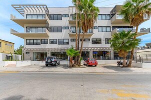 A multi-story building with a modern design, featuring balconies and large windows.