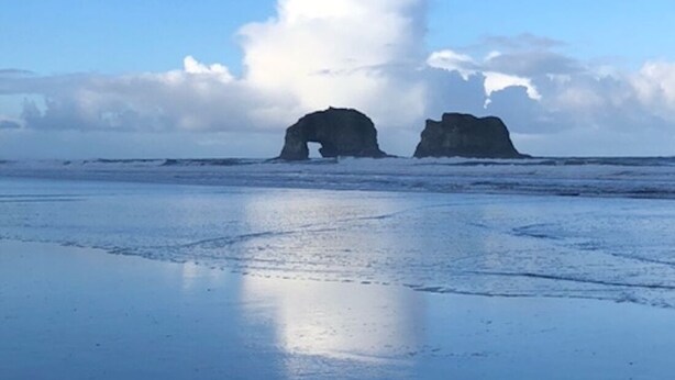 A beach with two rock formations and a clear sky. - Our Happy Place Steps from Rockaway Beach (Rockaway Beach)