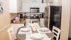 A compact kitchen with white cabinets, a stainless steel refrigerator, a microwave, an oven, and a sink. - 2 BR Dog-Friendly Condo W/ Free Golf Cart, Pool and Other Resort Amenities (Myrtle Beach)