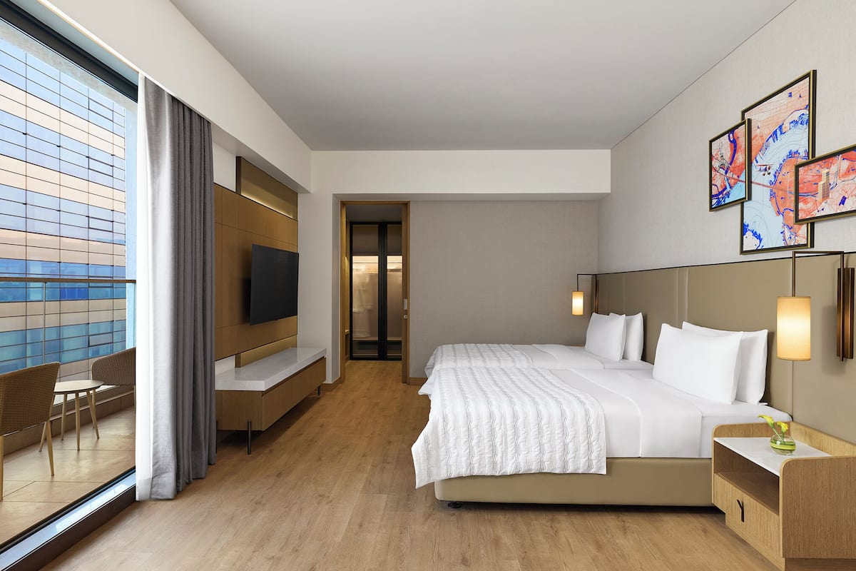 Een hotelkamer met een bed, een televisie, een bureau en een stoel.