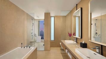 Un baño moderno con dos lavamanos, un espejo grande y una ducha con paredes de cristal.