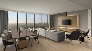 Een moderne woonkamer met een eethoek, een grote televisie en uitzicht over de stad.