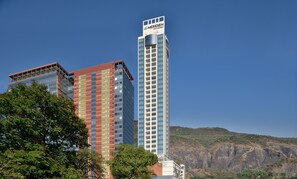 Een hoog hotel met een bord waarop 'Le Meridien Navi Mumbai' staat.