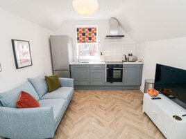 Una cucina moderna con mobili grigi, forno integrato e una finestra con un motivo colorato.