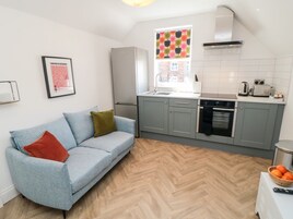 Una cucina moderna con mobili grigi, forno integrato e finestra con un motivo colorato.