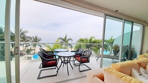 A balcony with a glass door, a round table, and four chairs.