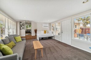 Relax in this cozy space with a comfortable bed, sofa, and coffee table.