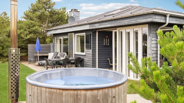 A house with a covered patio, a hot tub, and a chimney. - 3 bedroom stunning home in Ringkøbing (Ringkøbing)