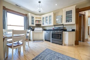Enjoy cooking in this well-appointed kitchen with a central island, sink, and stove, plus a dining area with a table and chairs.