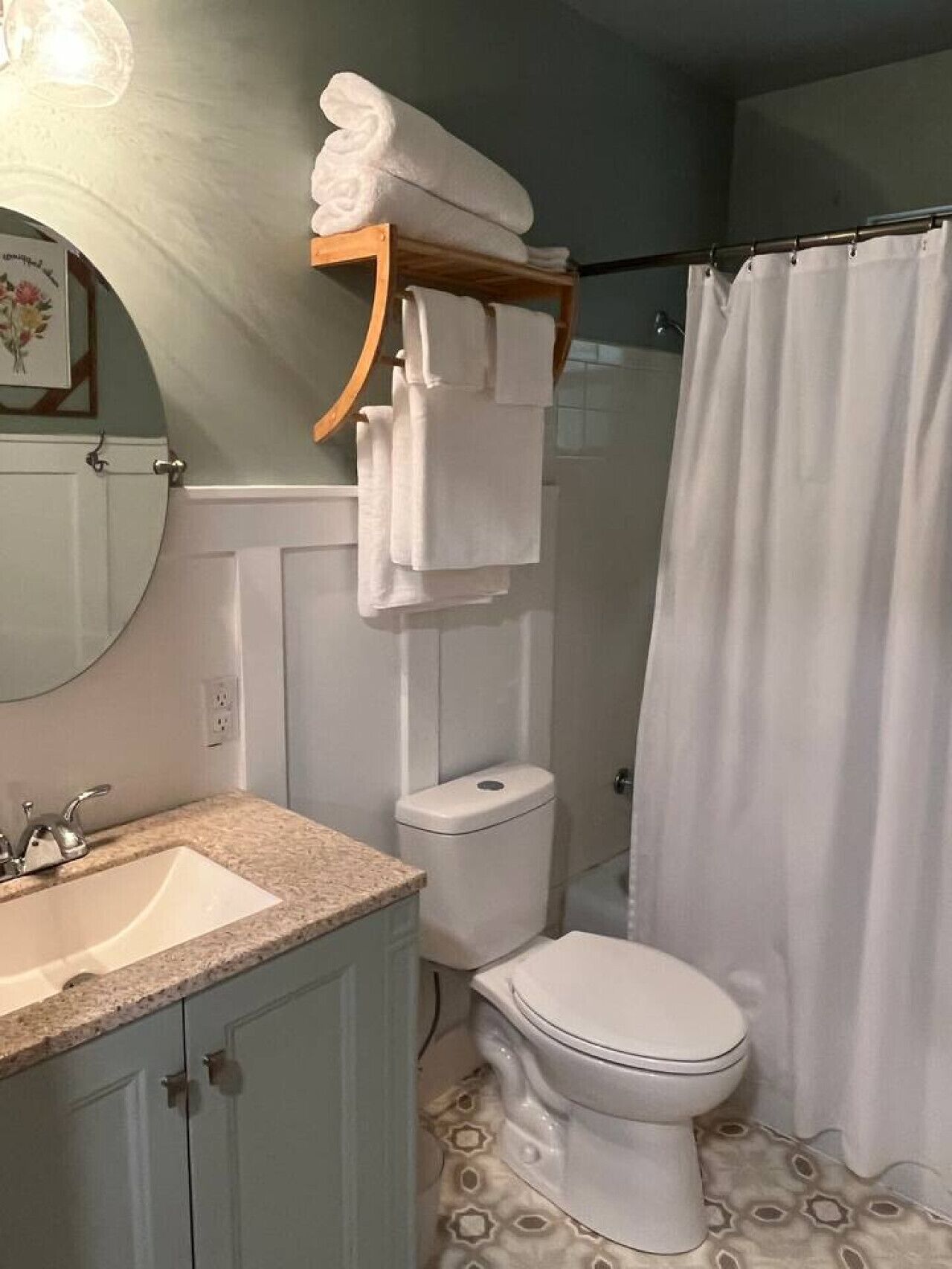 A bathroom with a sink, toilet, and shower curtain.