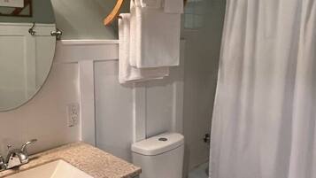 A bathroom with a sink, toilet, and shower curtain.