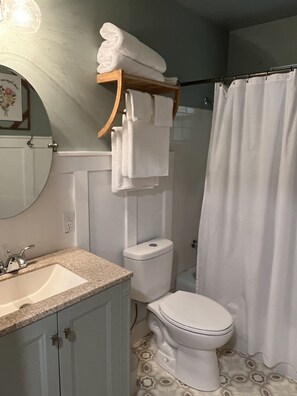 Baño con lavamanos, inodoro y cortina de ducha.