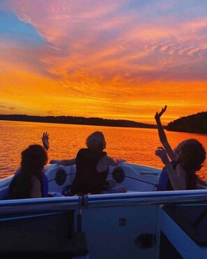 A boat with three people enjoying a sunset view. - Belle Cottage - on the shores of Table Rock Lake, walk to the water to swim, padde, relax (Eagle Rock)