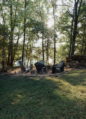 A forested area with a picnic table and chairs.