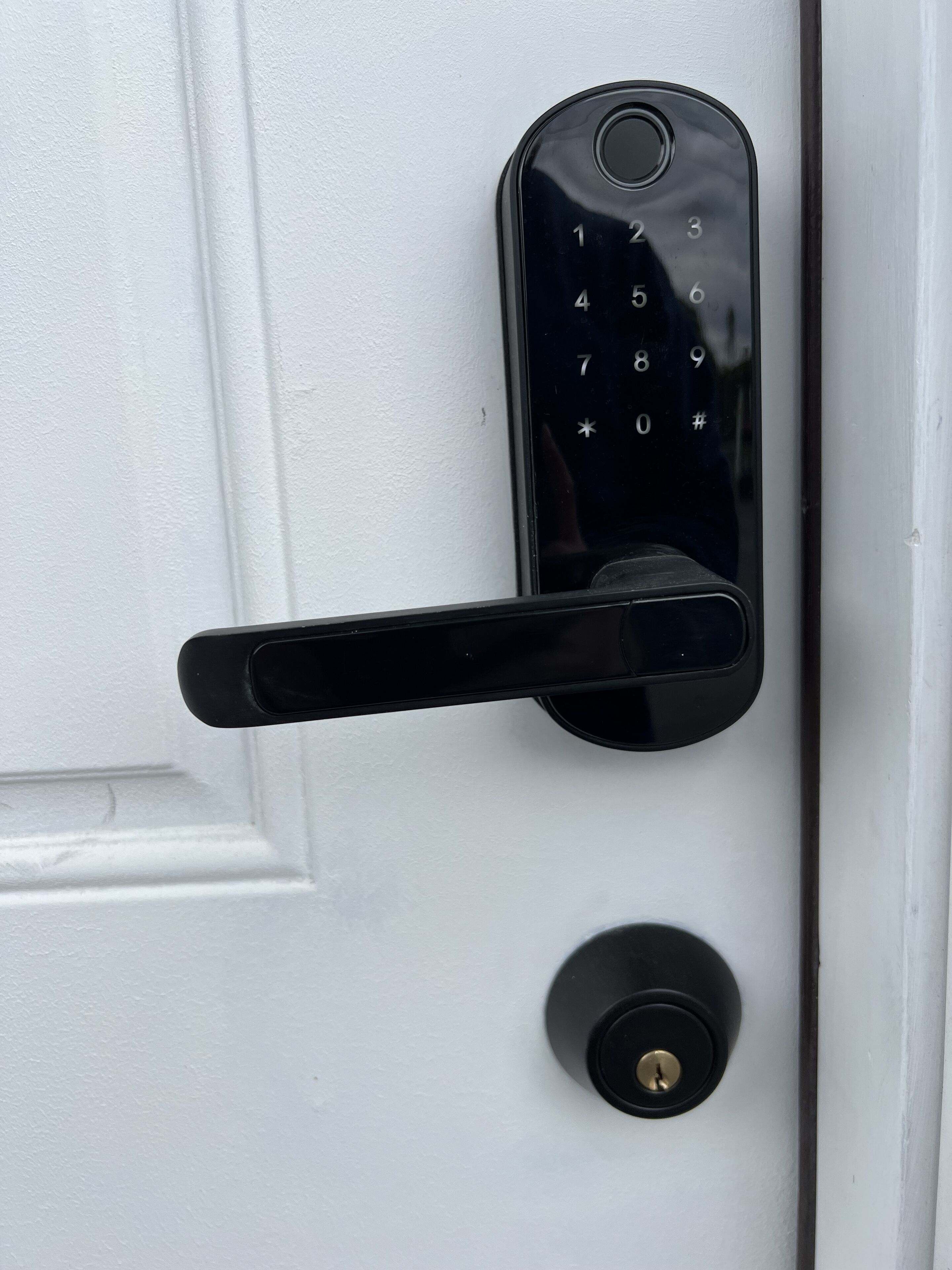 Een moderne deur met een numeriek keypad en een sleutelgat.