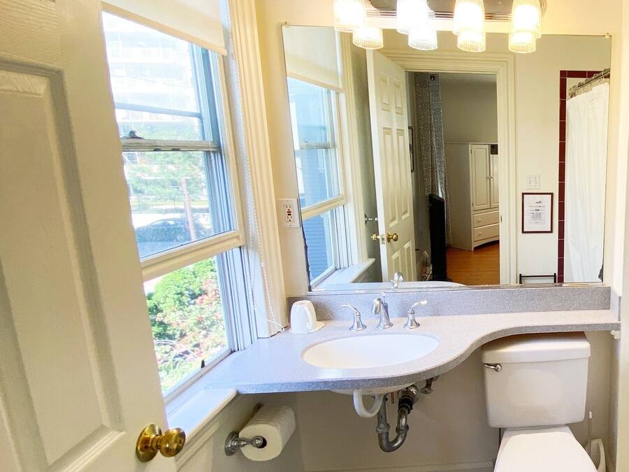 Bany amb un lavabo blanc, un vàter i una finestra.