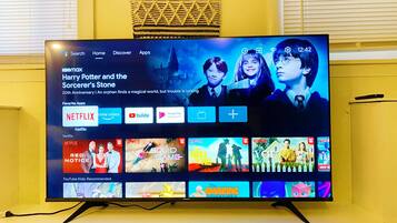 A television displaying a streaming service interface with various content options and a highlighted movie title.