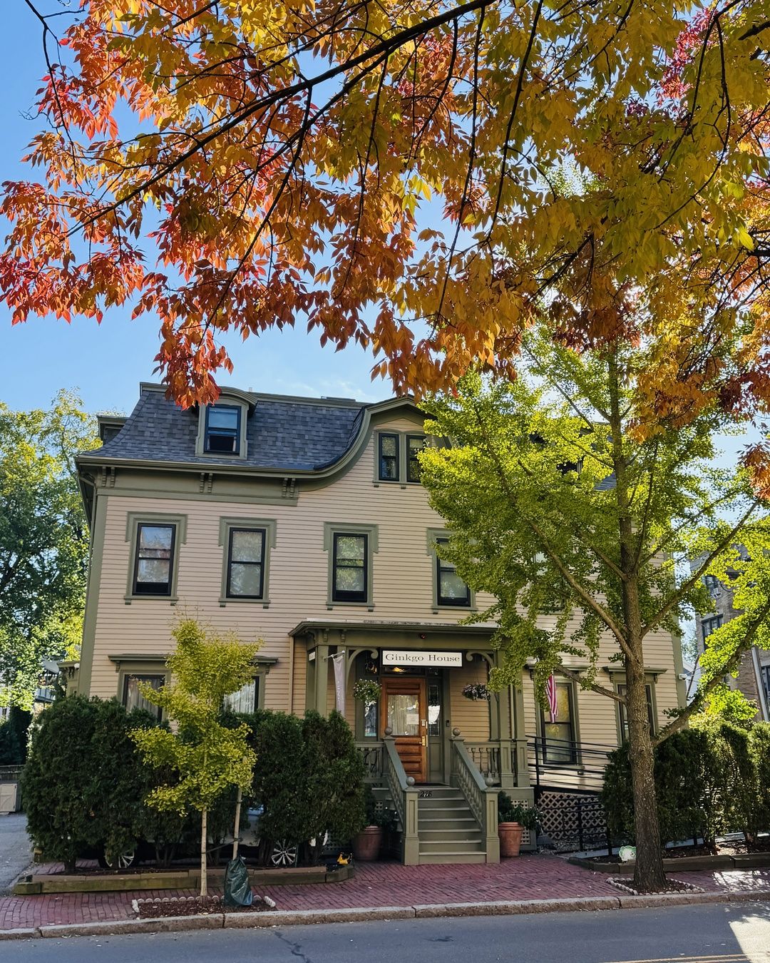 A two-story house with a front porch, a staircase, and a sign reading 'Ginkgo House.'