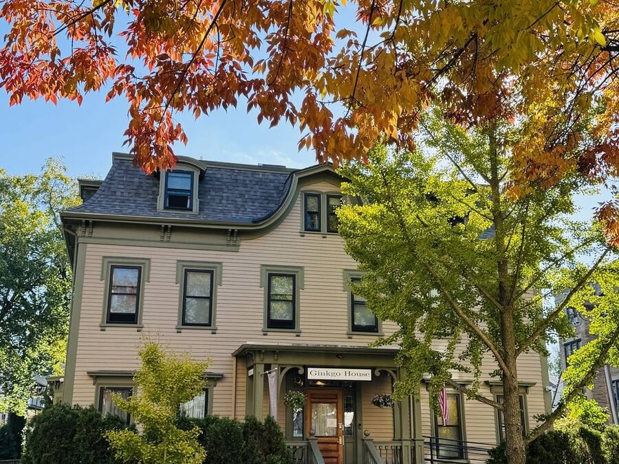 A two-story house with a front porch, a staircase, and a sign reading 'Ginkgo House.'