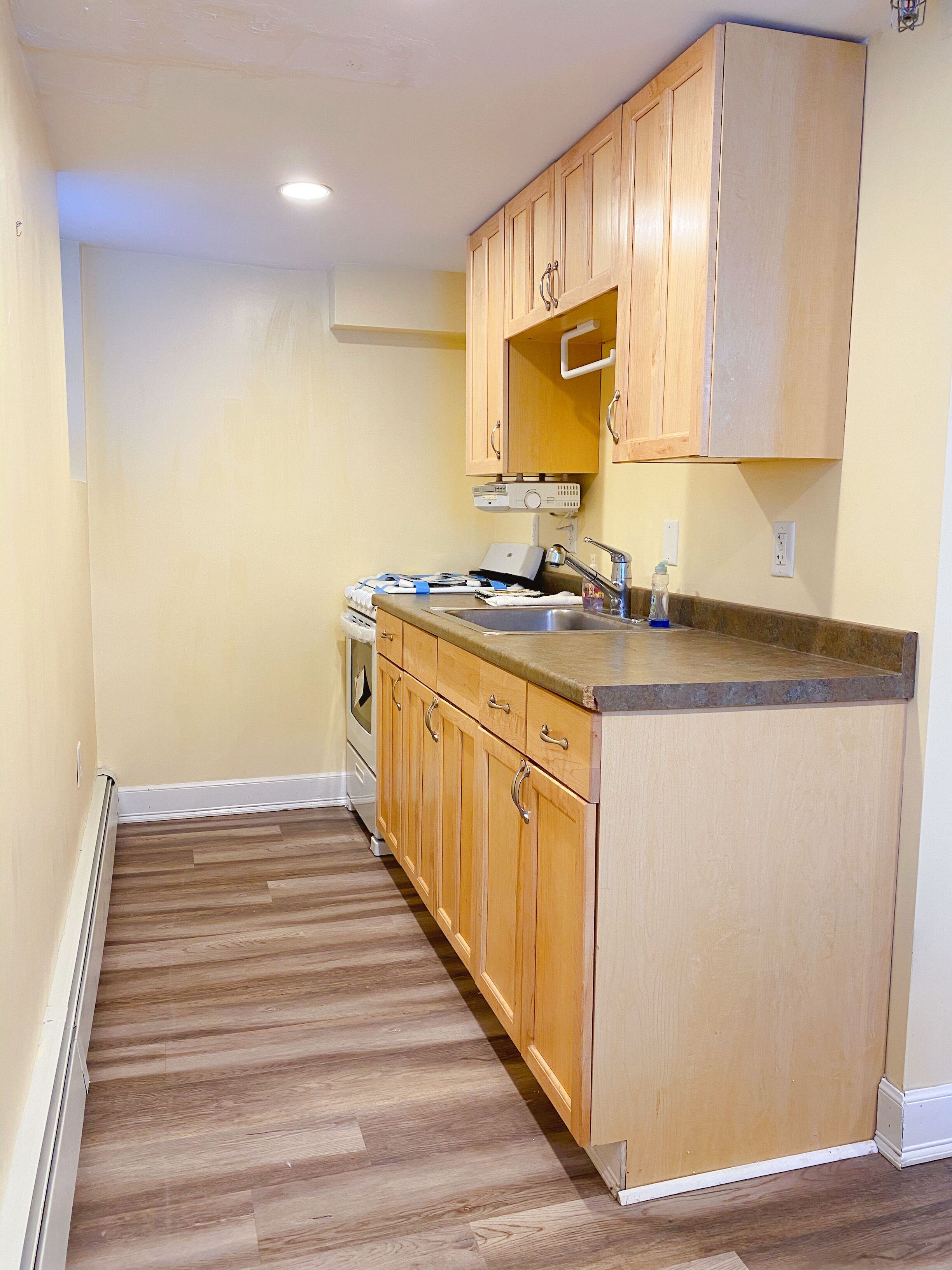 A kitchen with wooden cabinets, a countertop, and a built-in oven.