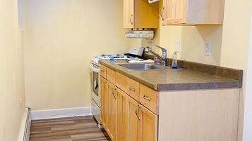 A kitchen with wooden cabinets, a countertop, and a built-in oven.