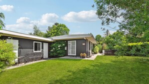 A modern two-story house with a covered patio and a well-maintained lawn.