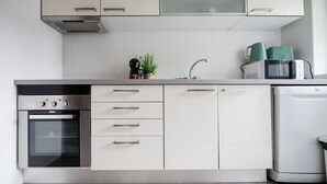 Eine moderne Küche mit weißen Schränken, einem Backofen, einer Mikrowelle und einem Geschirrspüler.