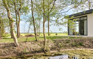 Situated in a serene natural setting, this building features clean lines and a neutral palette, blending seamlessly with the surrounding landscape.