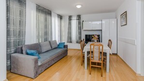 Un salon moderne avec un canapé gris, une table à manger en bois et des chaises.