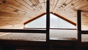 A sloped ceiling with wooden beams and a triangular window. - Deluxe Cabin6 Within Campground (Mifflinburg)