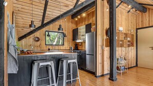 A modern kitchen with wooden walls, a built-in stove, and a large window. - Amazing home in Rødby with WiFi (Rødby)