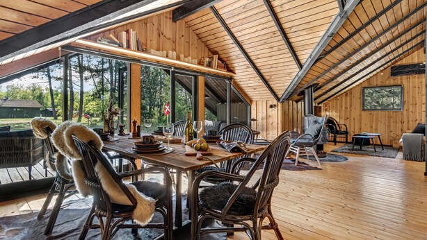 An interior with a dining area, wooden walls, and large windows. - Amazing home in Rødby with WiFi (Rødby)
