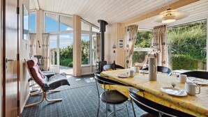 Una habitación acogedora con una gran mesa de comedor, sillas, un sofá y una chimenea.