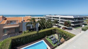 A modern building with a rooftop pool, a clear view of the ocean, and a well-maintained garden area. - Atlantic House - Beachfront Luxury House (Vila Nova de Gaia)