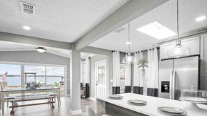 A modern kitchen with a large island, stainless steel appliances, and a view of the outdoors. - Beautiful 3 bedroom 2 bathroom waterfront home on Drs. Lake (Orange Park)
