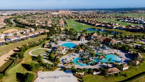 Vista aérea de un complejo turístico con varias piscinas, campos de golf y zonas residenciales.