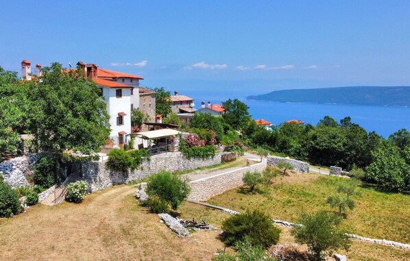 A coastal village with stone walls, terraced houses, and a clear view of the sea. - Stunning home in Plomin with house sea view (Plomin)