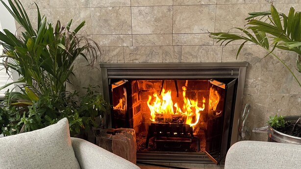 Ein gemütlicher Sitzbereich mit Kamin, zwei Sofas und einem runden Tisch mit Gläsern.