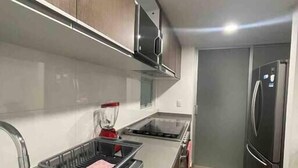 Een moderne keuken met roestvrijstalen apparatuur, een ingebouwde magnetron en een spoelbak.