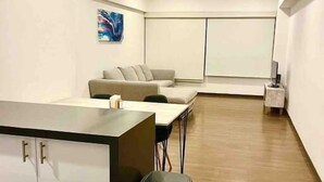 Eine moderne Küche mit integriertem Kochinsel, einer Couch und einem Mülleimer.
