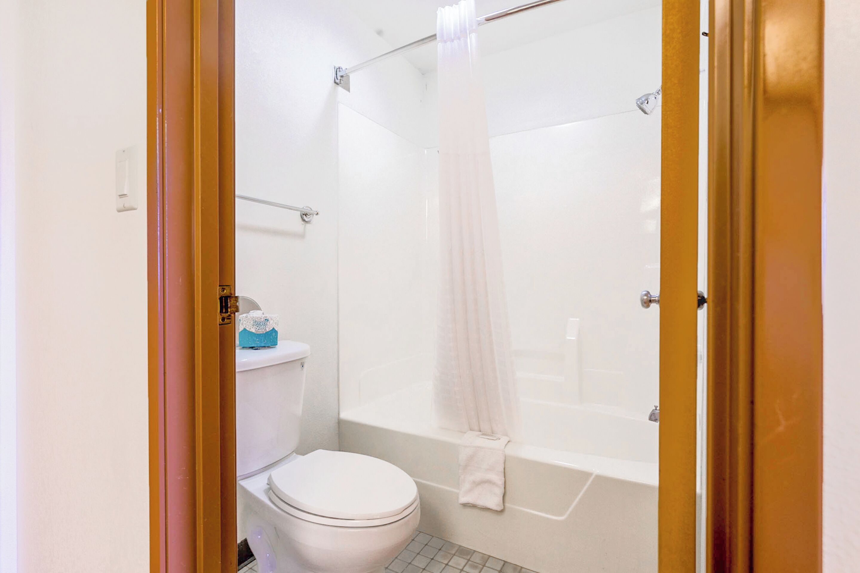A bathroom with a toilet, bathtub, and shower curtain.