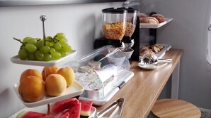 A breakfast buffet with various fruits, pastries, and a coffee machine. - The Queen Tropea  (Tropea)