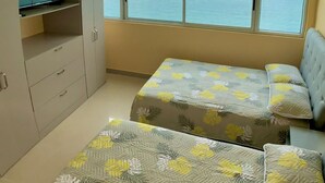A bedroom with two beds, a wardrobe, and a large window with a view of the sea. - 2P1-32 APARTAMENTO DE 2 ALCOBAS F. MAR (Cartagena)