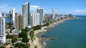 A coastal cityscape with high-rise buildings, a beach, and a clear blue sky. - 2P1-32 APARTAMENTO DE 2 ALCOBAS F. MAR (Cartagena)