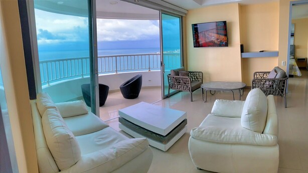 A modern living room with a balcony overlooking the sea, featuring white sofas, a coffee table, and wicker chairs. - 2P1-32 APARTAMENTO DE 2 ALCOBAS F. MAR (Cartagena)