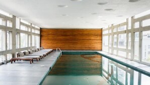 Une pièce longue et étroite, avec un mur en bois et une piscine.