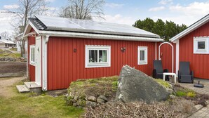 Un bâtiment rouge avec un toit en pente et des panneaux solaires.